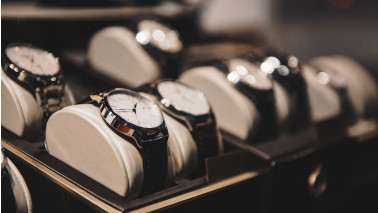 Armbanduhren werden einzeln nebeneinander in einer Ausstellungsbox präsentiert.