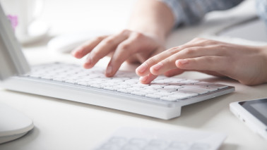 Hände tippen auf Tastatur. 